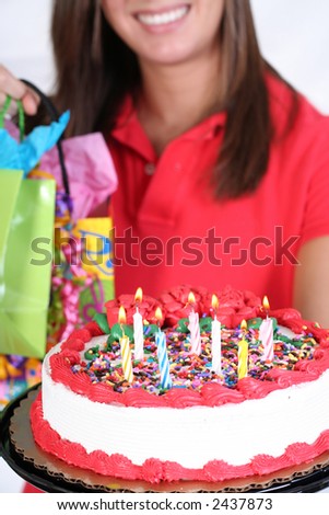 smiling female with birthday cake and presents