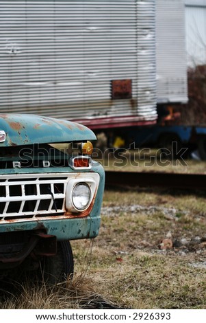 Turquoise weathered truck abandoned  in a junk yard