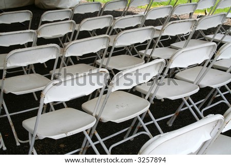 Rows of empty folding chairs outside...set up for a wedding