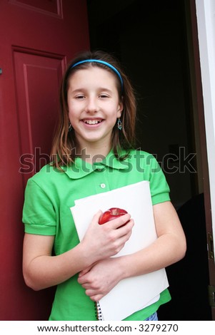 Cute girl going out the door to school with an apple
