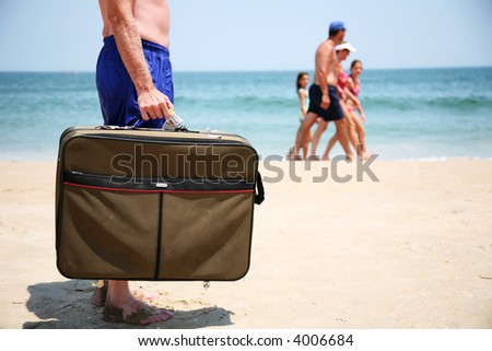 Man with a suitcase on the beach