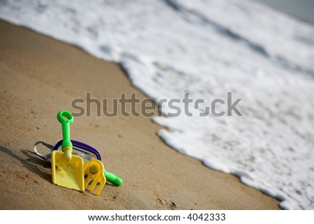 Toys on the beach with a wave coming in