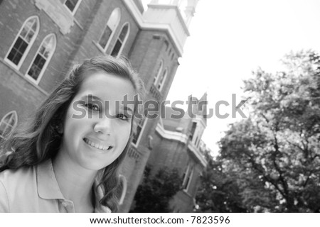 Female college student on campus with buildings in the background