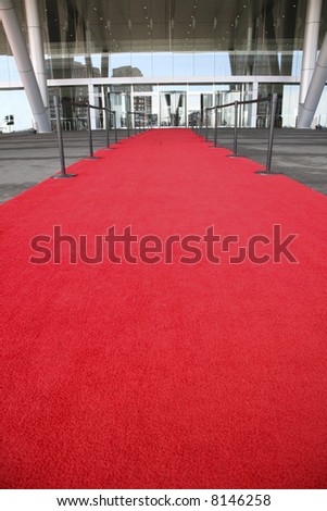 Red carpet celebrity entrance into a glass building