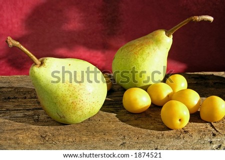pears on wooden table on red background