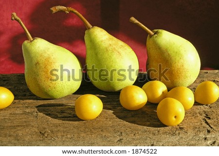 pears on wooden table on red background