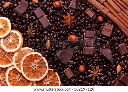 Background of coffee beans, chocolate chips, spices, nuts and candied fruit