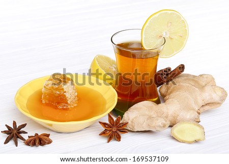 Tea with ginger, honey, lemon and spices on a light wooden background