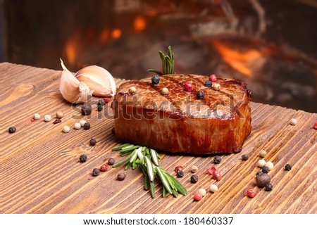 Grilled beef steak on a background of fire