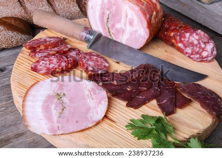 Sliced cold meats on a cutting board, top view