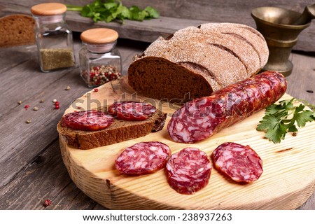 Sliced salami and bread on a cutting board