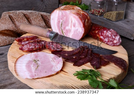 Sliced cold cuts and knife on a cutting board