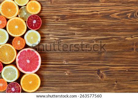 Citrus fruit cut in half - oranges, lemons, tangerines, grapefruit on a wooden background