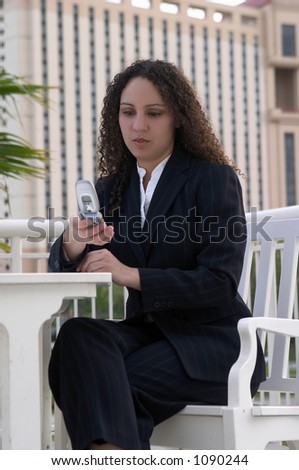 Serious Young Latina Business Woman Using Cell Phone