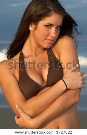 Beautiful Young Brunette Woman in Brown Bikini Top Hugging Herself