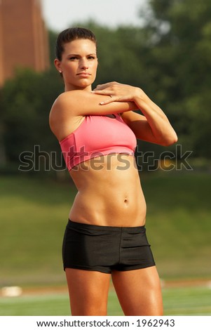 Beautiful Young Woman in Pink Sports Bra Stretching Arm