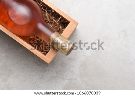 White Zinfandel, Blush Wine: A bottle of Rose wine in a wood box with packing straw. Item is positioned in the upper right corner with copy space.