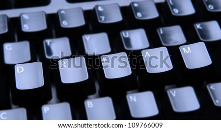 The word Dream spelled out on a computer keyboard. Only the keys forming Dream are in focus.
