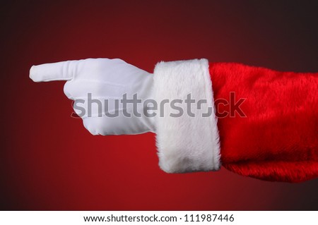 Santa Claus pointing, hand and arm only. Horizontal format over a light to dark red background.
