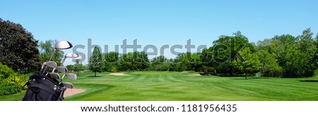 Golf Banner: A Golf bag with clubs on a par three tee box. Blue Sky and room for copy.