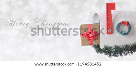 Mail Box with Christmas present with Merry Christmas and Happy New Year on a silver bokeh background with snow effect.