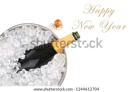 Top view of a champagne bottle in metal ice bucket with the words Happy New Year with room for your copy.