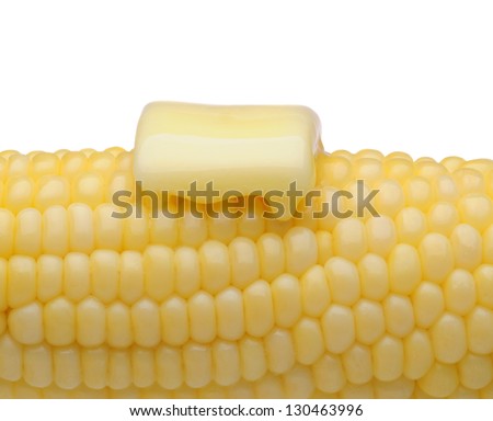 Closeup of an ear of corn on the cob with a pat of melting butter. Horizontal format on white.