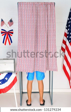 A Young male Voter inside a Voting Booth at his local polling place.