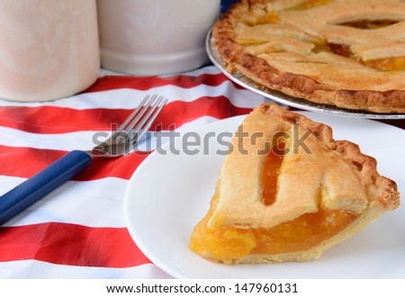 A slice of pie on an American Flag table cloth at a 4th of July picnic.