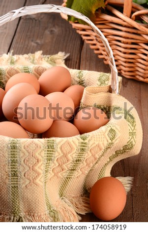 Closeup of a basket full of brown eggs in a rustic farmhouse like setting. Horizontal format with shallow depth of field.