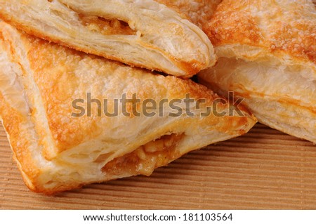 Closeup of Apple Turnovers ona brown paper surface. Horizontal format filling the frame.