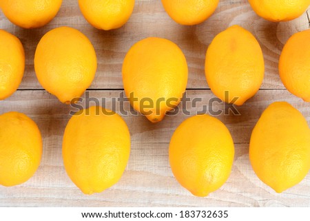 High angle shot of rows of whole lemons filling the frame. Horizontal format or a rustic farmhouse style table.