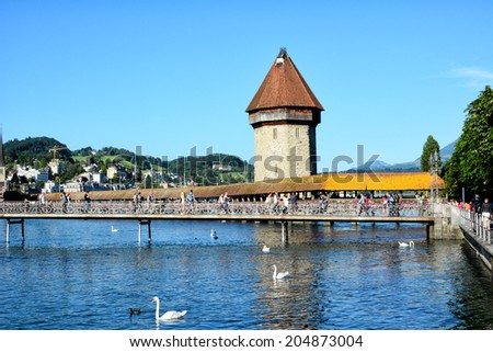 LUCERNE, SWITZERLAND - July 4, 2014: Chapel Bridge or Kapellbrucke is the oldest wooden covered bridge in Europe. The 170 meter bridge spans the Reuss River.