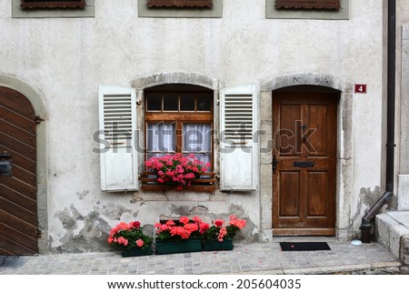 GRUYERES, SWITZERLAND - JULY 8, 2014: Front door on traditional Swiss home. The picturesque  home is on the cobblestone main street in old town Gruyeres leading to the castle and church.