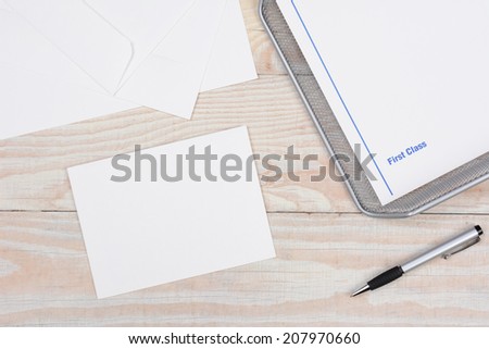 Envelopes and paper for writing letters via snail mail. High angle shot with in-box and pen on a whitewashed desk.