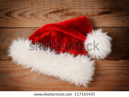 Santa Claus Hat on a rustic wooden floor with an instagram retro look. High angle view with vignette.