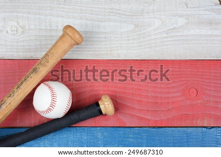 High angle shot of a baseball and bats on a red, white and blue picnic table. Horizontal format with copy space. Suitable for American Holidays: 4th of July and Memorial Day,