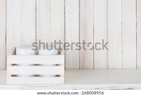 Closeup of a pair of salt and pepper shakers in a small wood box on a white wood rustic kitchen shelf. Horizontal format with copy space.