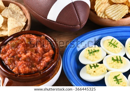 Closeup of snacks for watching a football game, chips, salsa and deviled eggs. Great for Super Bowl or Playoff themed projects.