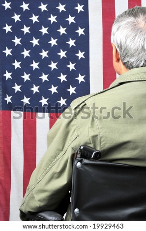 American veteran in wheelchair and fatigues facing flag