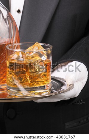 Waiter in tuxedo holding Cocktail and Decanter on tray vertical format torso only