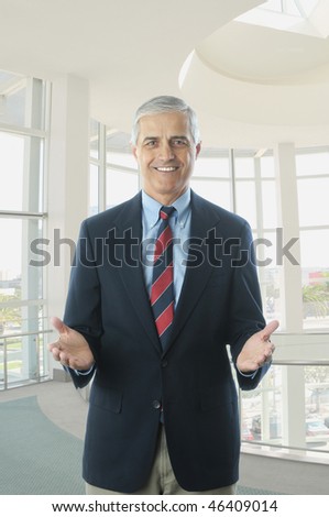 Middle Aged Businessman in Blue Blazer Hands Extended in Office Setting
