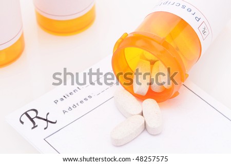 Looking down on a group of prescription bottles on Prescription Form with pills spilled horizontal composition