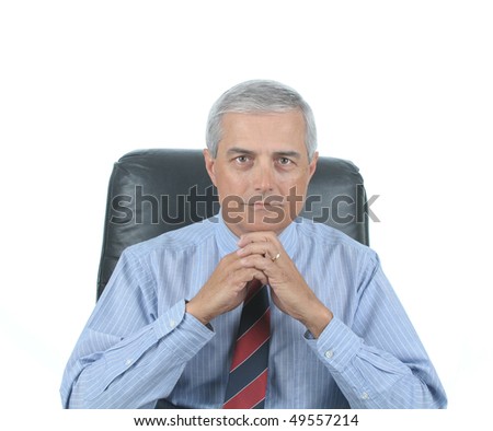 Middle aged businessman sitting at his desk with hands clasped under chin isolated over white