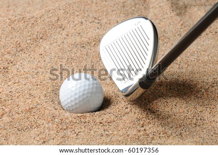 Golf Ball in Trap with Sand Wedge about to strike the Golfball. Close up in horizontal composition with copy space.