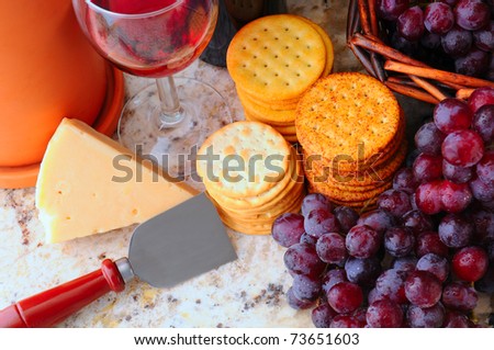Wine, cheese, crackers and grapes still life. Horizontal format viewed from a high angle.