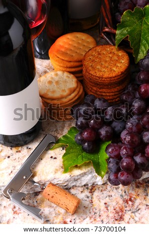 Wine Still life with corkscrew, grapes and crackers. Vertical format with side window light.