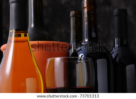 Closeup Wine Bottle still life with wineglass and strong window side light.  Horizontal format with shallow depth of field.