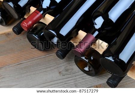 Closeup of a wine rack full of bottles on a rustic wooden table.