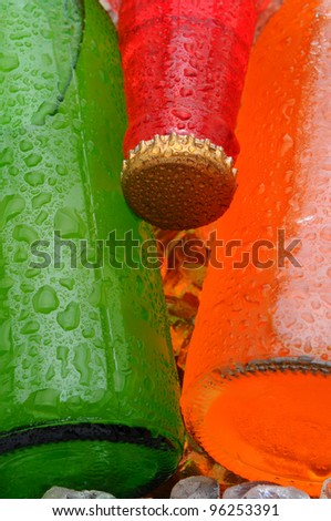 Closeup of three different soda bottles with condensation.